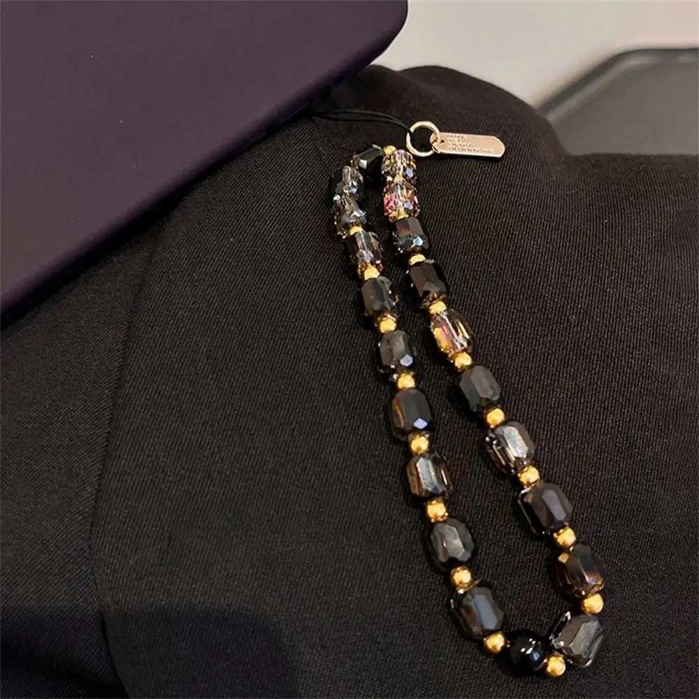 Phone Strap de Cristal Preto e Ouro: Luxo e Proteção 📱✨